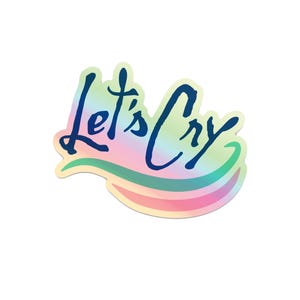 Peut inclure: Un autocollant holographique avec un fond arc-en-ciel et un contour bleu. L'autocollant dit "Let's Cry" dans une police d'&eacute;criture manuscrite.