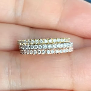 Könnte beinhalten: Drei Ewigkeitsringe mit einer Pavé-Fassung aus Diamanten. Die Ringe sind aus Gelbgold, Weißgold und Roségold.