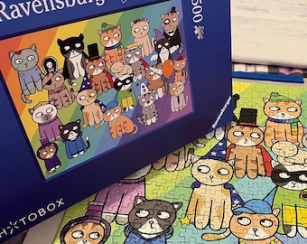 May include: A 500-piece Ravensburger puzzle featuring a colorful illustration of cartoon cats in various costumes. The puzzle box is dark blue with the Ravensburger logo and the word "Puzzle". The completed puzzle is partially assembled, showing more of the cat characters.