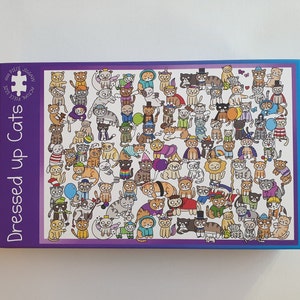 May include: A jigsaw puzzle box with a purple border and the words "Dressed up Cats." The puzzle features numerous cartoon cats in various costumes and outfits. The puzzle is labeled as 1000 pieces.