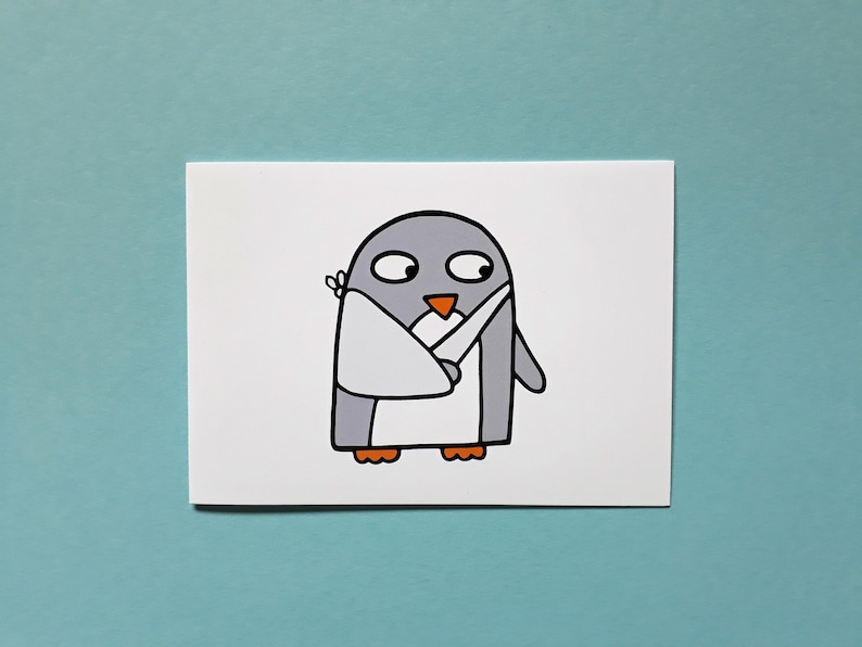 May include: A cartoon illustration of a penguin with a white bandage on its wing. The penguin is grey with an orange beak and feet. The image is on a white card against a light blue background.