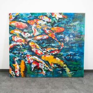 Könnte beinhalten: Großes quadratisches Gemälde mit einem Schwarm Koi-Karpfen. Das Kunstwerk zeigt Koi in Orange-, Gelb-, Rot- und Weißtönen vor einem Hintergrund aus blauem und grünem Wasser. Das Gemälde hat einen strukturierten, impressionistischen Stil.