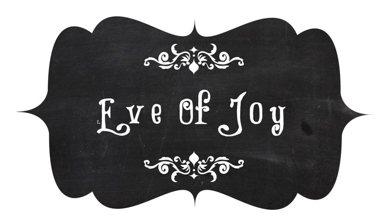 May include: Black chalkboard sign with white decorative flourishes and the text "Eve of Joy" written in a stylized font.