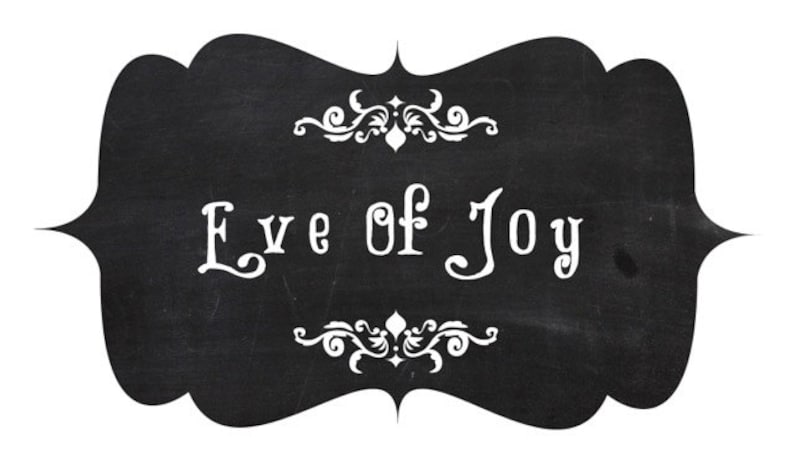 May include: Black chalkboard sign with white decorative flourishes and the text "Eve of Joy" written in white.