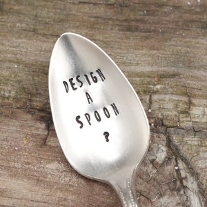 May include: A silver spoon with the text "DESIGN A SPOON?" engraved on the front.
