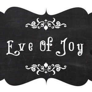 May include: A chalkboard-style sign with a black background and white text that reads "Eve of Joy." The sign has a decorative, ornate border at the top and bottom. The overall design is simple and elegant.