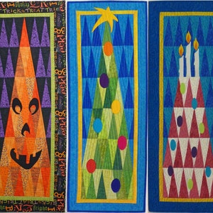 May include: Three quilted wall hangings with a triangular design. The first is orange and black with a jack-o-lantern face. The second is green and blue with a Christmas tree design. The third is red and blue with a birthday cake design.