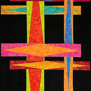 May include: Abstract quilt with a geometric design featuring intersecting lines and diamond shapes in shades of red, orange, yellow, blue, and green on a black background.