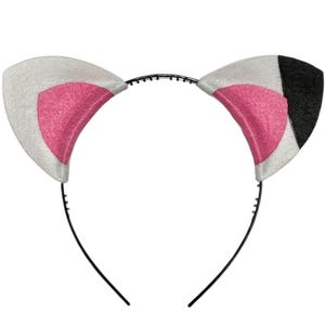 May include: A cat ear headband featuring white, pink, and black details. The ears are white with pink inner sections and a black segment on one ear. The headband is black and has a simple design.