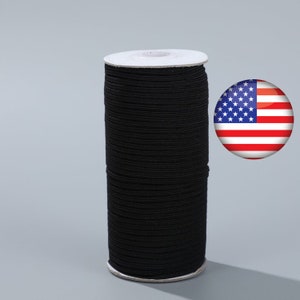 Puede incluir: Una bobina de cordón elástico negro, enrollada alrededor de un núcleo de cartón blanco. El cordón se utiliza para coser y proyectos de manualidades.