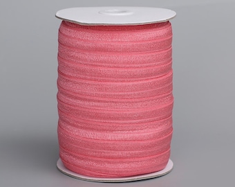 Puede incluir: Una bobina de elástico rosa doblado, también conocido como FOE, para proyectos de costura y manualidades.