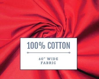 May include: A vibrant red fabric with a white rectangular overlay containing the text 100% COTTON and 60" WIDE FABRIC. The material features soft folds and a smooth texture, showcasing the solid red color across the entire visible surface area.