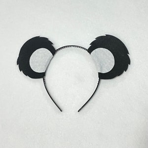 May include: Black felt panda ears headband with a black plastic headband. The ears have white felt inside.