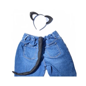 May include: A blue denim pair of jeans with a black felt cat tail attached to the back waistband. A black felt headband with white felt cat ears is also included.