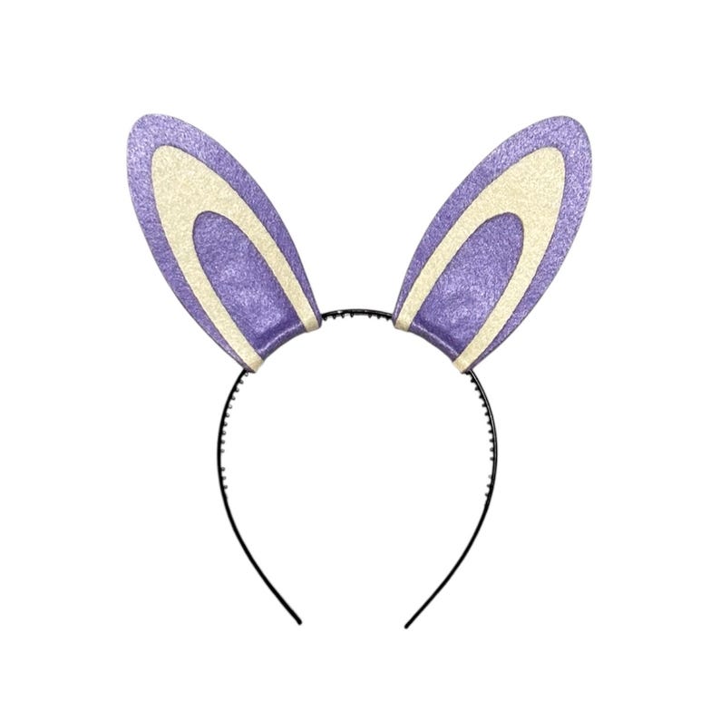 Puede incluir: Una diadema con dos orejas de conejo moradas y brillantes, con el interior de las orejas de color crema. Las orejas est&aacute;n unidas a una fina diadema de pl&aacute;stico negro. El dise&ntilde;o es sencillo y festivo, adecuado para Pascua o eventos de disfraces.