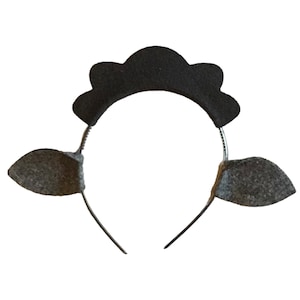May include: A black sheep headband with gray felt ears and a black felt top. The headband is made of a thin, silver-colored metal. The sheep ears are attached to the headband with a thin wire.