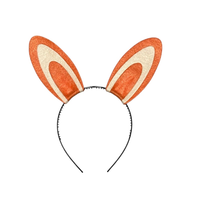 Puede incluir: Una diadema negra con dos orejas de conejo naranjas y crema. Las orejas, de aspecto texturizado, est&aacute;n erguidas. La diadema, de dise&ntilde;o minimalista, es ideal para Pascua o disfraces.