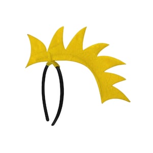May include: A yellow felt headband with a spiky design. The headband has a black plastic band and a series of yellow, pointed shapes extending from the top. The design is reminiscent of a crown or a burst of energy.