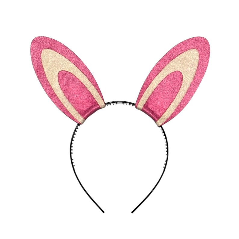 Puede incluir: Una diadema con orejas de conejo rosas y blancas. Las orejas son de un rosa vibrante con una secci&oacute;n interior crema. La diadema es negra y tiene un dise&ntilde;o simple y curvado. Ideal para celebraciones de Pascua o disfraces.