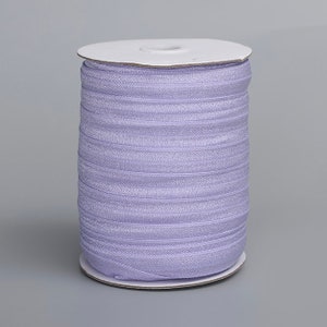 May include: A spool of lavender-colored elastic, wound around a white cardboard core. The elastic is thin and has a subtle sheen.