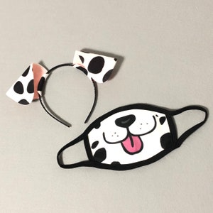 以下が含まれることがあります： 黒と白のダルメシアン犬の顔のマスク。ピンクの舌と白い斑点のある黒いヘッドバンドが付いている。