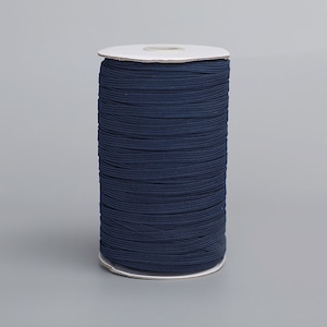 May include: A spool of dark blue elastic cord, wound tightly on a white cardboard spool.