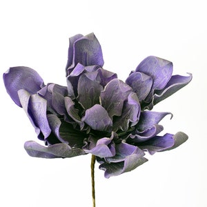 May include: A single, large, purple artificial flower with a textured, ruffled appearance. The flower has a long, thin stem.