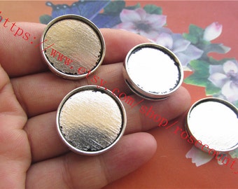 May include: Four silver-toned round metal trays with a smooth, reflective surface. The trays are approximately 1 inch in diameter and have a slightly raised edge.