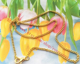 May include: A gold chain necklace with a lobster clasp closure. The chain is made of small, linked circles.