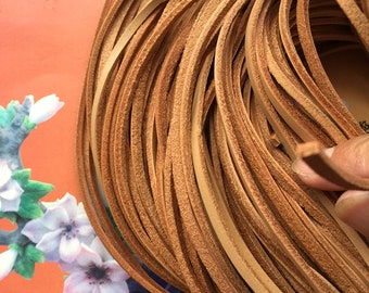May include: A close-up of a bundle of light brown leather cord. The cord is smooth and supple, and it is perfect for crafting projects.