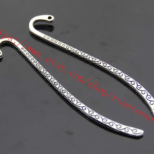 Op de afbeelding: Twee zilveren bladwijzer hangers met een decoratief swirl-ontwerp. De bladwijzers zijn ongeveer 15 cm lang.