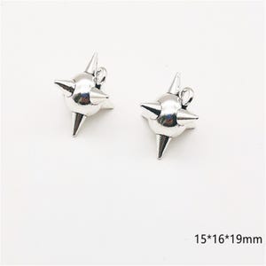 May include: Two silver-colored, star-shaped charms with pointed spikes. Each charm has a small loop at the top for attaching to jewelry. The charms measure 15mm x 16mm x 19mm.
