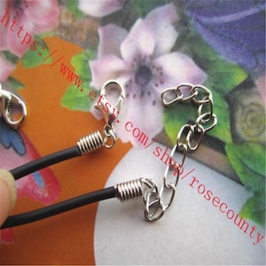 Puede incluir: Un collar de cord&oacute;n negro con terminales de metal plateado, un cierre de mosquet&oacute;n y una cadena extensora ajustable. Los componentes del collar est&aacute;n fabricados con un cord&oacute;n negro liso y herrajes de metal pulido de color plateado.
