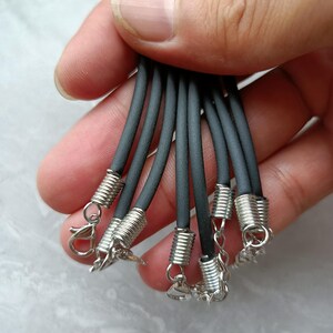 Puede incluir: Un conjunto de cordones negros de caucho para collares con terminales de metal plateado en forma de espiral, cierres de mosquet&oacute;n y cadenas de extensi&oacute;n cortas. Los cordones son lisos, flexibles y de grosor uniforme para joyer&iacute;a.