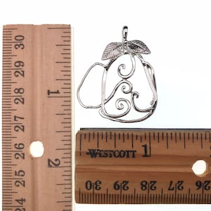 Puede incluir: Encanto de plata en forma de pera con un dise&ntilde;o de espiral y hojas. El encanto mide aproximadamente 2,5 cm de largo. El encanto se mide contra una regla.