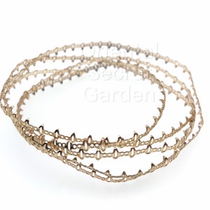 May include: Three gold-colored metal trim pieces with a decorative, scalloped edge. The trim is designed for use in crafts and home decor projects.