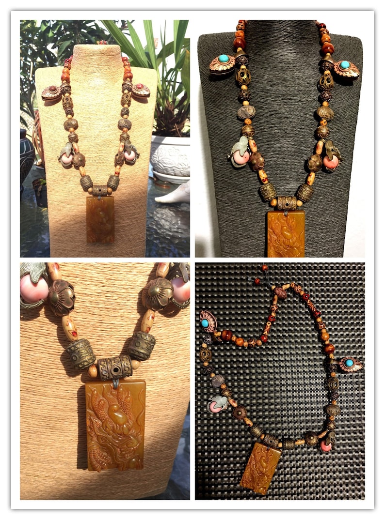 Puede incluir: Un collar largo y multicolor con un gran colgante de &aacute;mbar tallado. El collar presenta cuentas de madera, cuentas de metal y peque&ntilde;as cuentas talladas de color rosa y blanco. El colgante es rectangular y presenta una talla detallada de un drag&oacute;n.