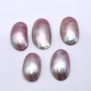 May include: Five iridescent pink oval-shaped mother of pearl shell cabochons. The shells have a pearlescent sheen and are perfect for crafting.