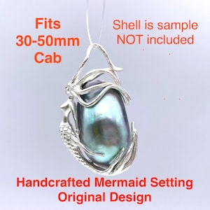 May include: A handcrafted mermaid setting pendant with an original design. The silver-toned pendant holds a large, iridescent, oval-shaped cabochon. The text on the image reads: "Fits 30-50mm Cab" and "Handcrafted Mermaid Setting Original Design."