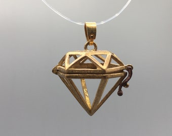 May include: A gold-toned diamond-shaped pendant necklace with a hinged opening. The pendant is made of wire and has a delicate, intricate design.