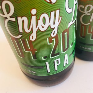 May include: A green and brown beer bottle with a white label that says "Enjoy 4-20 IPA".
