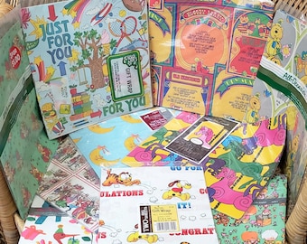 May include: A wicker basket filled with colorful wrapping paper featuring various cartoon characters and designs. The wrapping paper includes themes like "Just for You", "Go for It!" and "Congratulations".