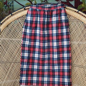 May include: A red, white, and blue plaid skirt with a high waist and a straight silhouette.