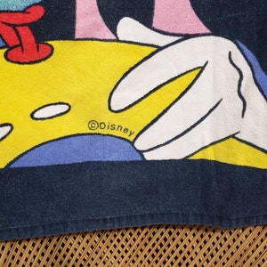 May include: A blue and yellow beach towel featuring a cartoon image of Mickey Mouse with the text "&copy;Disney" and "Mickey".