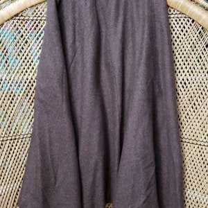 May include: A brown knee-length skirt with a flared hem. The skirt is made of a soft, textured fabric.
