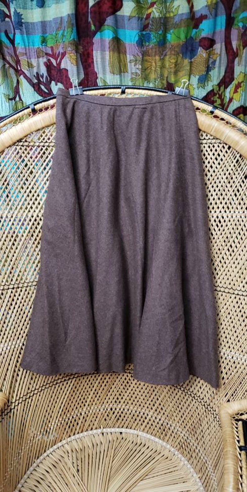 May include: A brown knee-length skirt with a flared hem. The skirt is made of a soft, textured fabric.