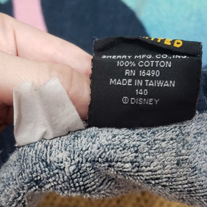 May include: A black tag with white text that reads "SHEART MFG. CO., INC. 100% COTTON RN 16490 MADE IN TAIWAN 140 DISNEY".