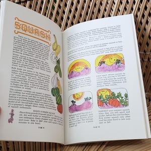 May include: Open book with the title "SQUASH" in orange letters. The pages feature text and colorful illustrations of squash plants and their growth stages. The book is held open by a hand, with a woven background.