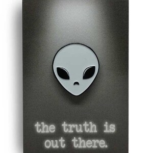 May include: A gray alien face with black eyes and a frown. The text "the truth is out there" is below the alien face.