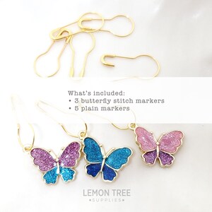 May include: A set of eight gold stitch markers, including three butterfly stitch markers with glitter accents in pink, blue, and purple, and five plain gold stitch markers. The text "What's included: 3 butterfly stitch markers 5 plain markers" is visible in the image.